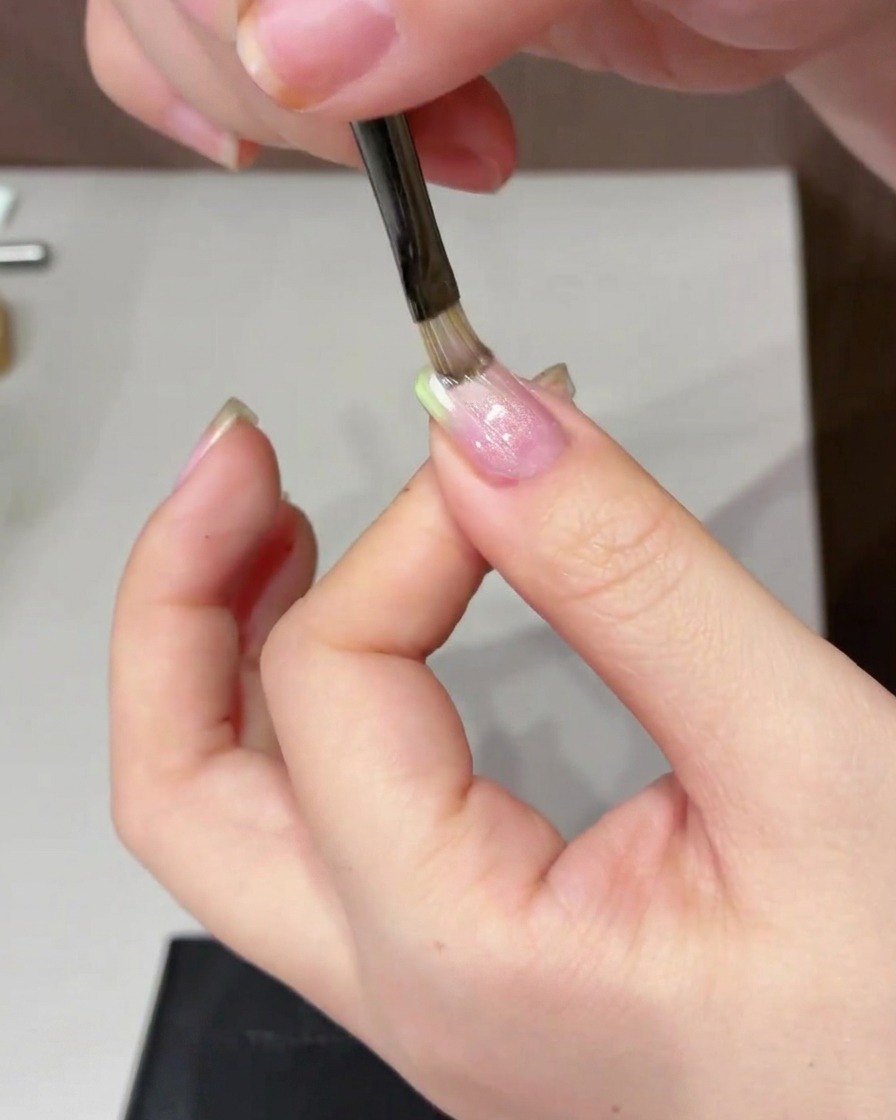 Ein zylindrischer Magnet wird seitlich über den Nagel bewegt, um den Cat-Eye-Effekt zu erzeugen.