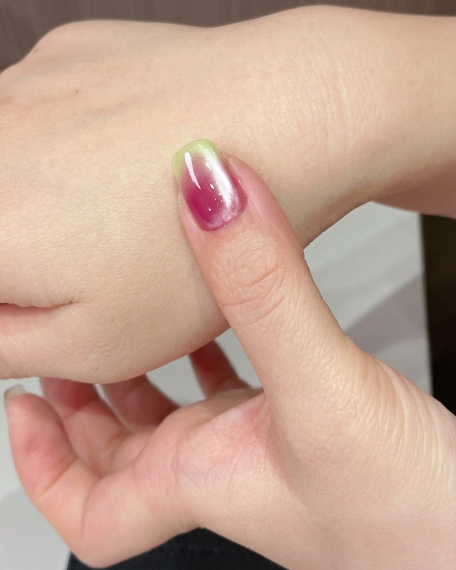 Eine Hand wird unter einer UV-Lampe positioniert, um das Cat-Eye-Gel auszuhärten.