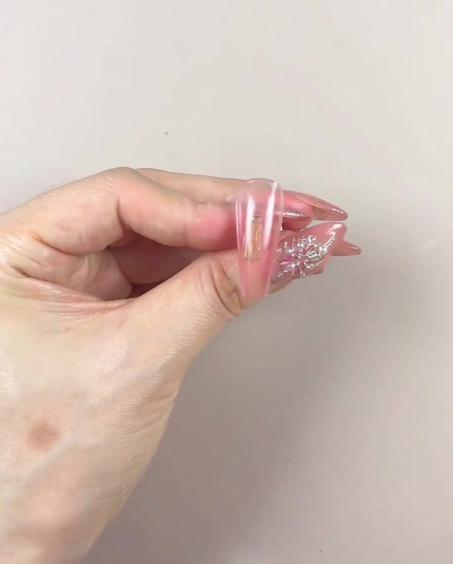 Eine manikürte Hand in einer UV/LED-Lampe beim Aushärten der Gelschicht.