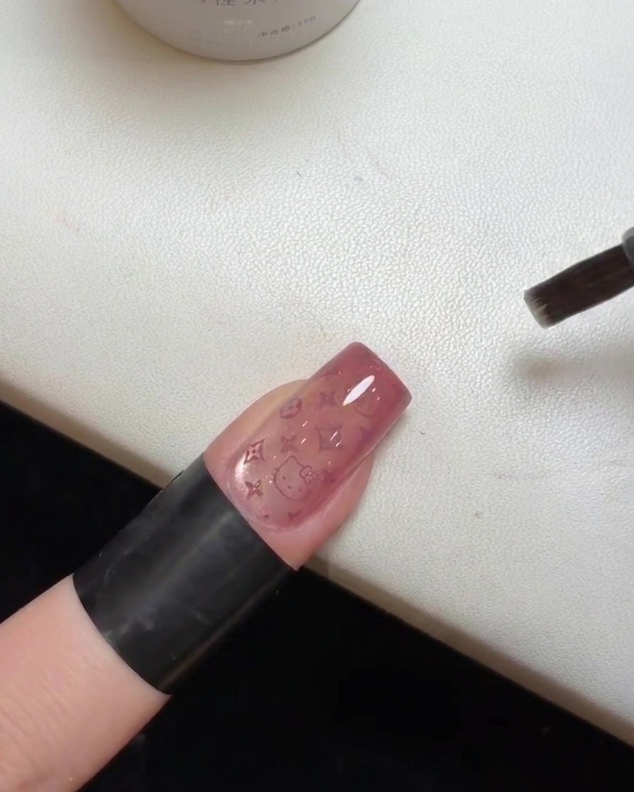 Nahaufnahme eines fertigen Nagels, dessen Top Coat unter einer UV-Lampe ausgehärtet wird.