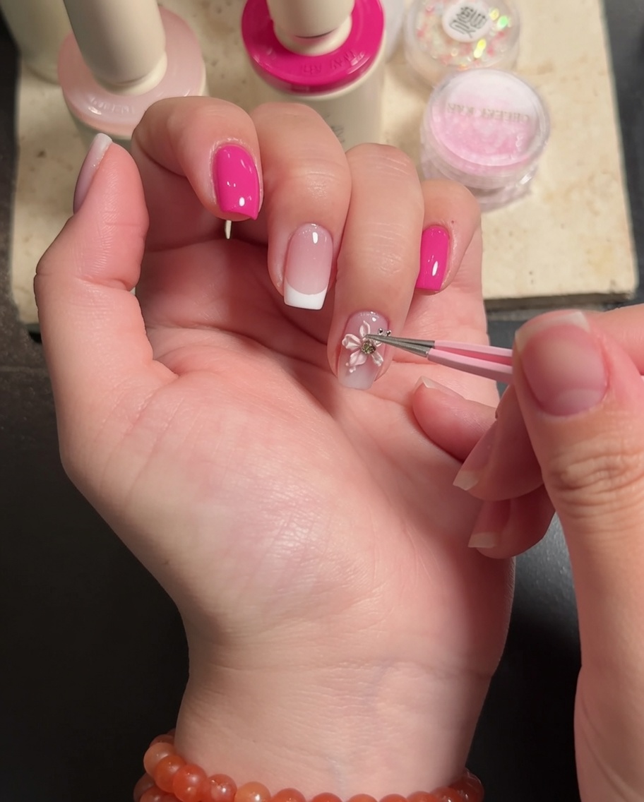Ein Pinsel trägt eine finale Schicht Top Coat um die 3D-Blumenverzierung auf.