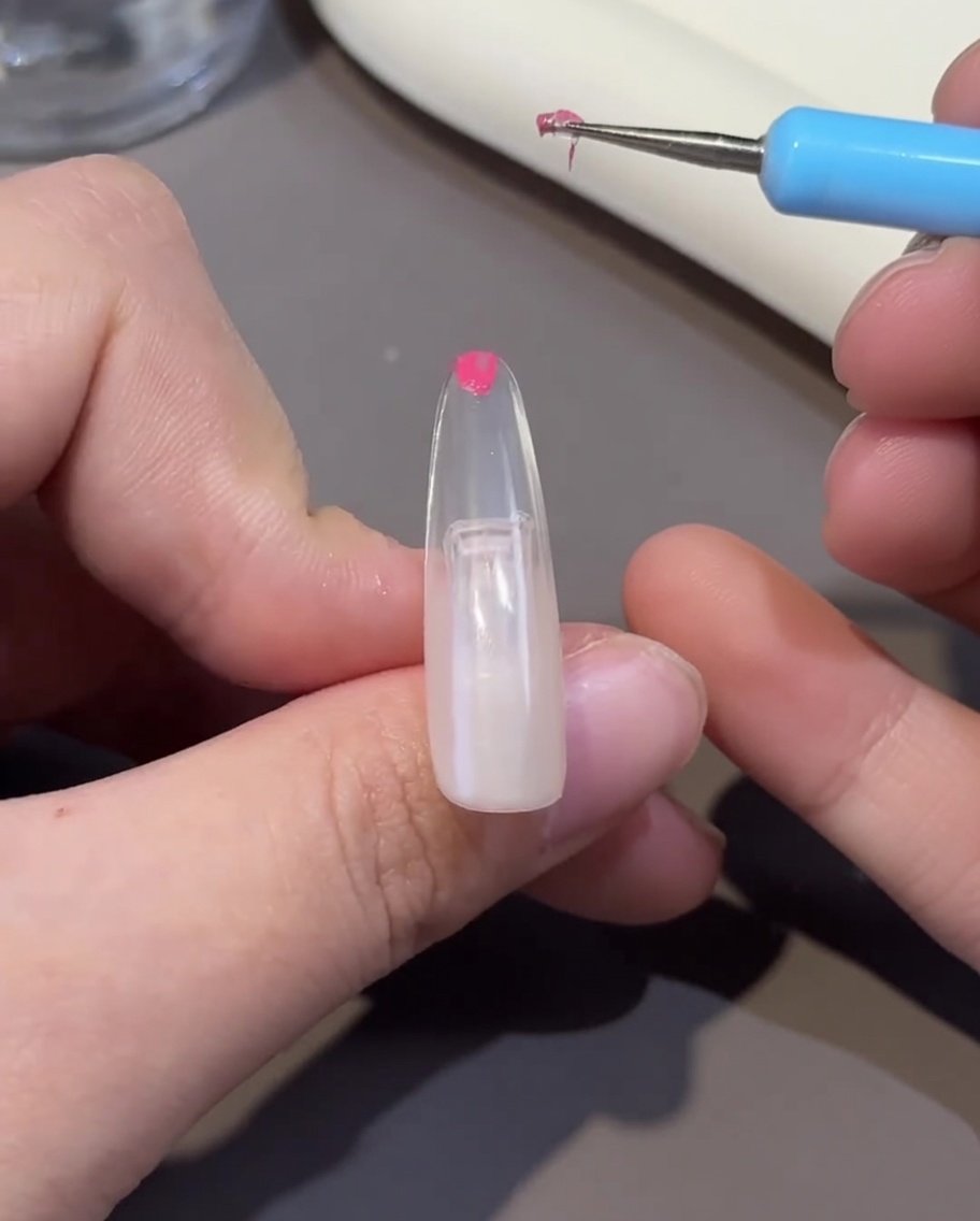 Ein Nagel-Tip wird unter einer UV/LED-Lampe ausgehärtet, die Oberfläche des Gels ist fest.