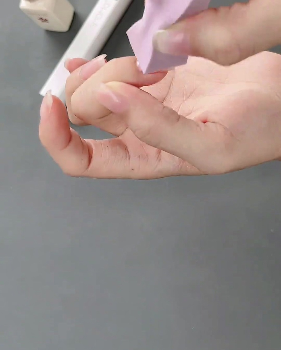Ein Make-up-Schwämmchen tupft weißes Gel auf den Naturnagel, um einen weichen Verlauf zu erzeugen.
