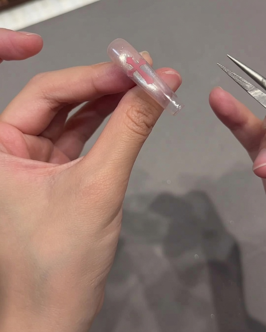 Ein fusselfreies Tuch wird verwendet, um die Oberfläche eines fertigen Cat-Eye-Nagels zu reinigen.