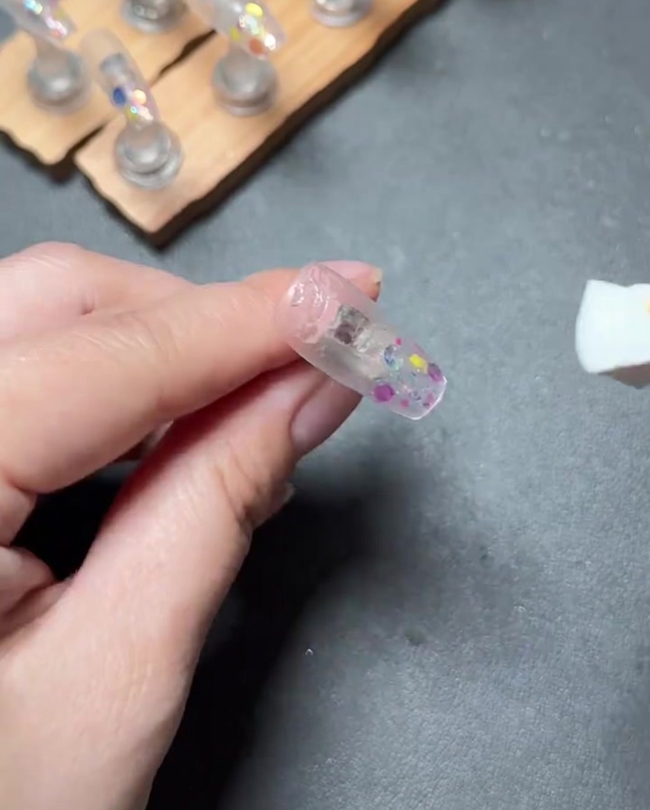 Eine Nagelfeile, die zum Polieren der Oberfläche eines Press-on-Nagels verwendet wird, um ein glattes Finish zu erzeugen.