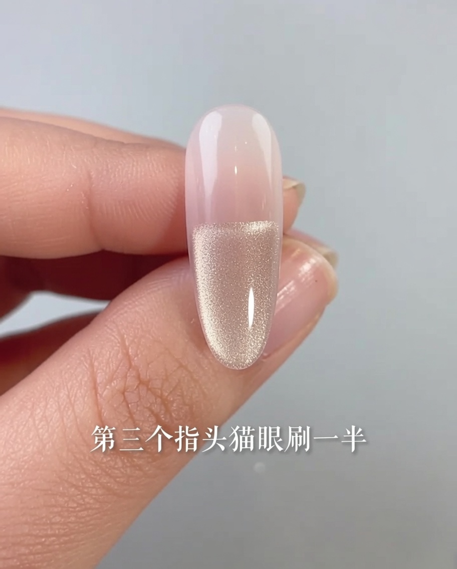 Nahaufnahme eines Fingernagels mit Cat-Eye-Gellack, der nur auf die untere Hälfte des Nagelbetts aufgetragen wird.
