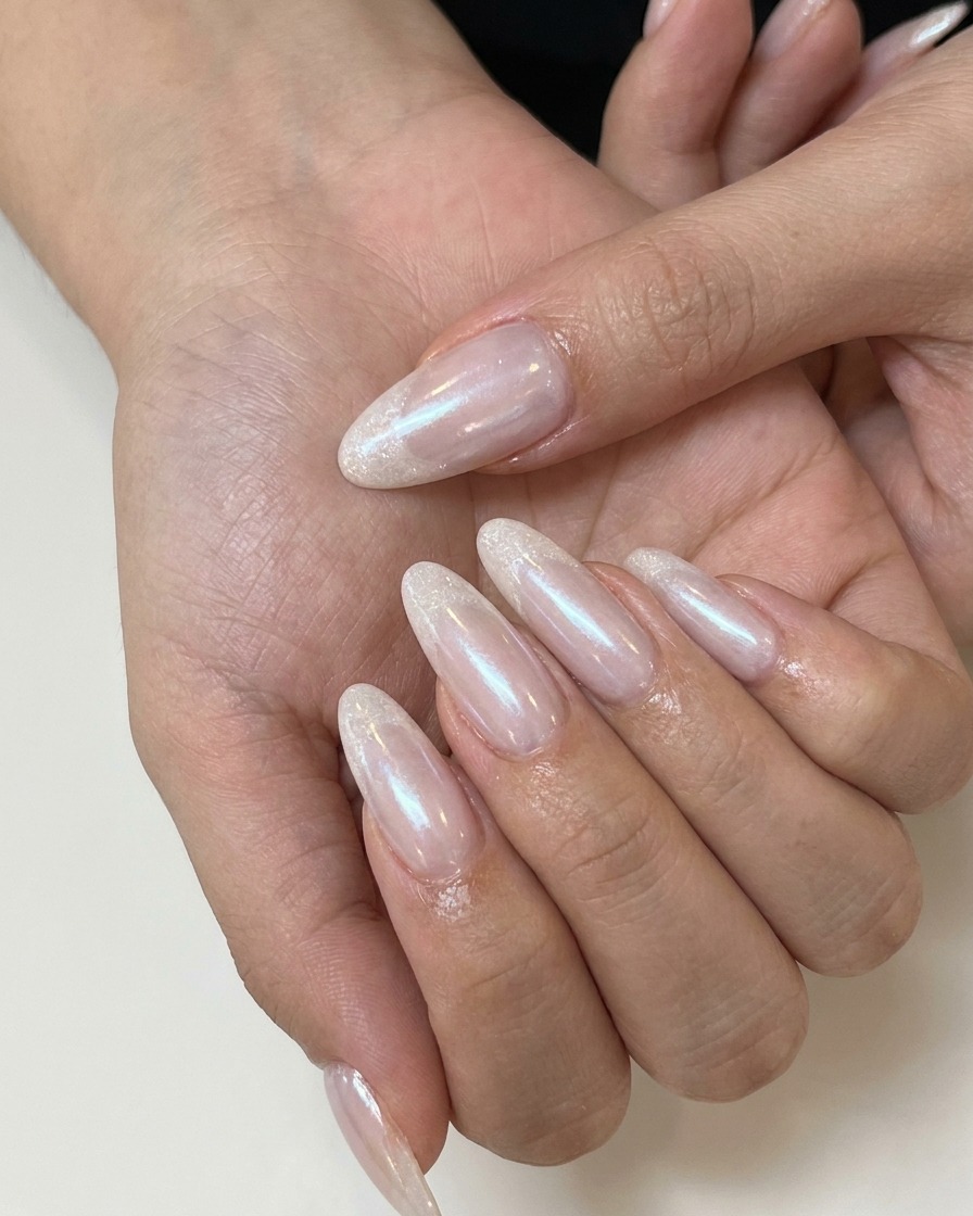 Eine Nageldesignerin trägt matten Top Coat auf einen rosafarbenen Nude-Gelnagel auf.