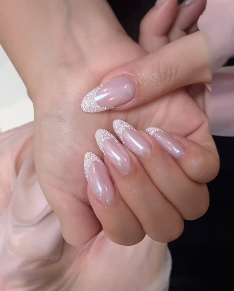 Ein fusselfreies Tuch reinigt die Oberfläche eines matten Nude-Pink-Nagels.