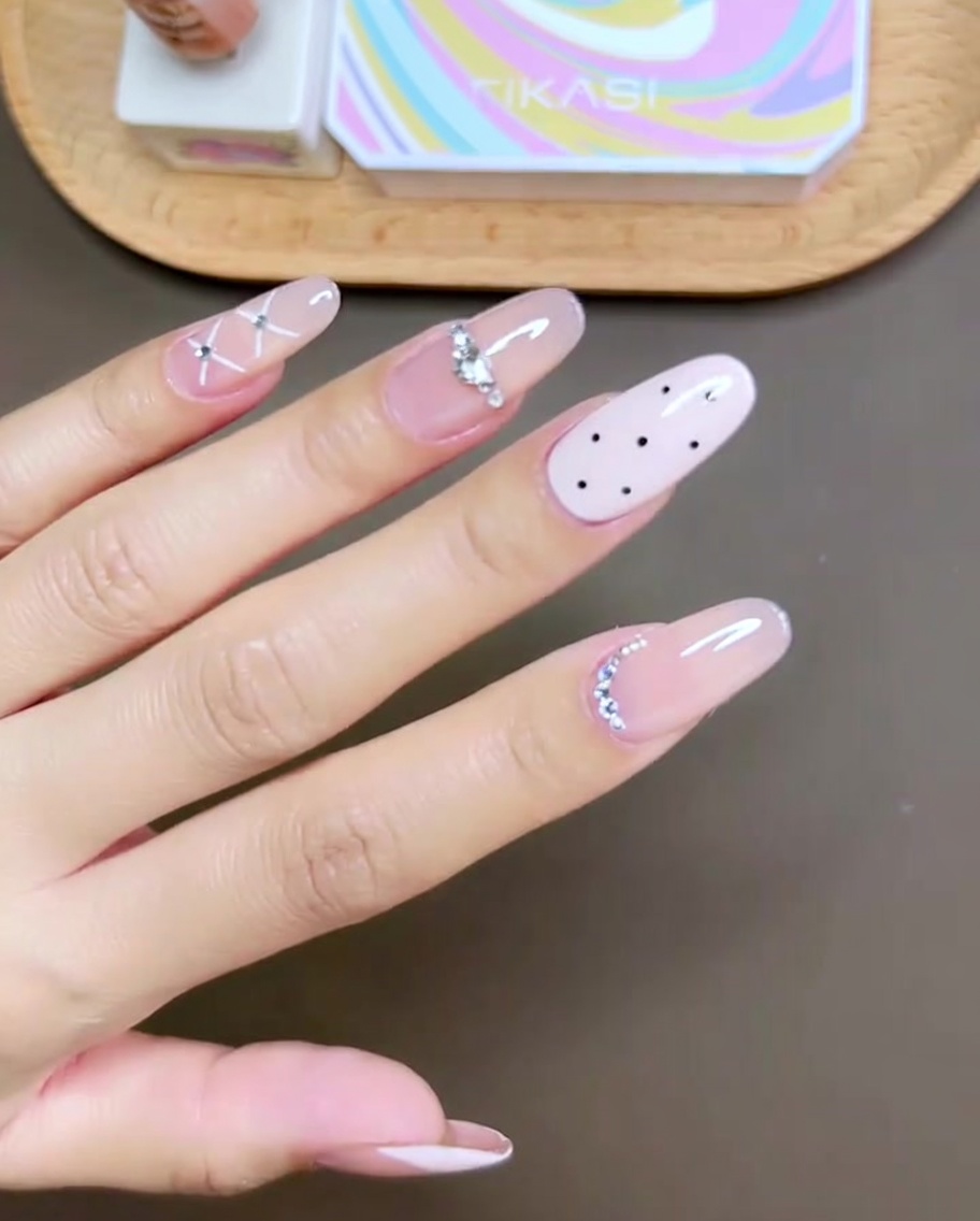 Nahaufnahme eines Pinsels, der rosa Gel-Lack auf einen Mittelfinger aufträgt.