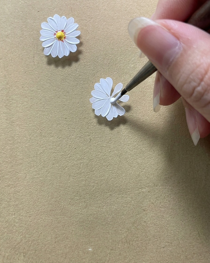 Ein Detailpinsel perfektioniert die inneren Ränder der Blütenblätter, um eine runde Fläche in der Mitte freizulassen.