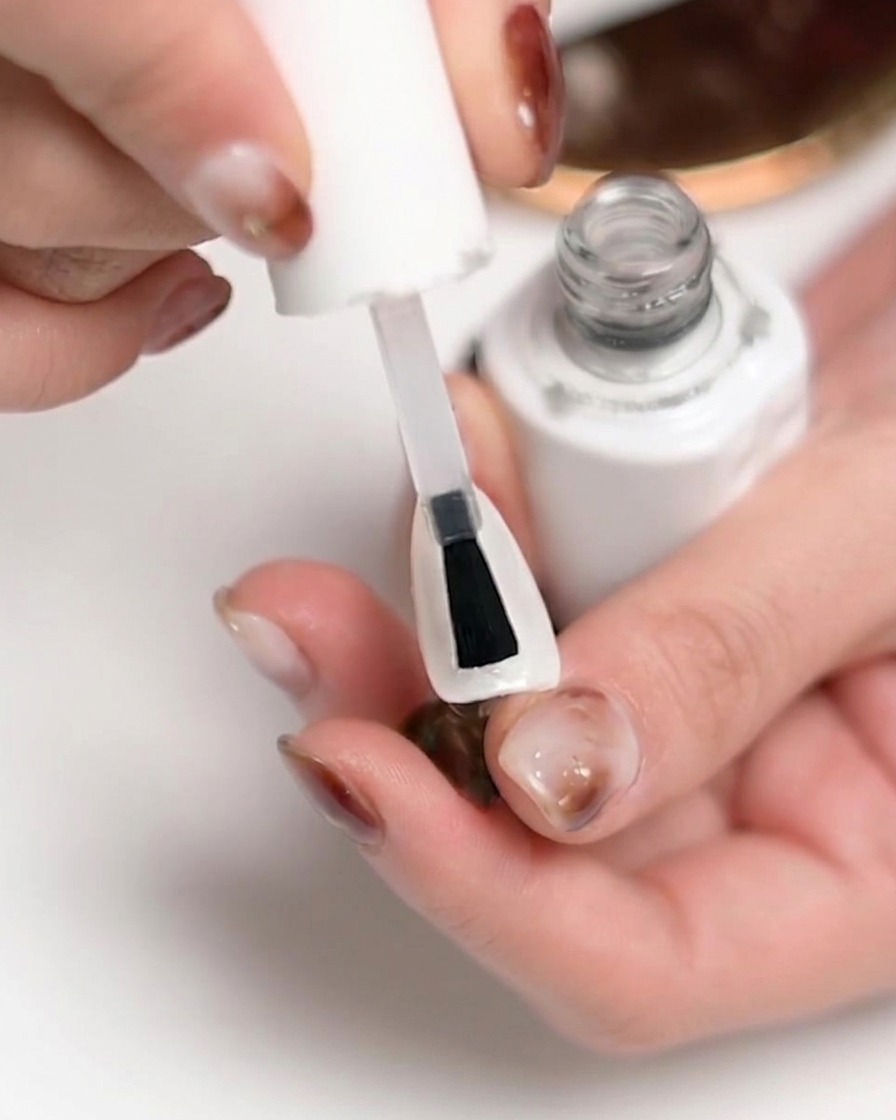 Eine Hand in einer UV/LED-Nagellampe, während der Aushärtungsprozess stattfindet.