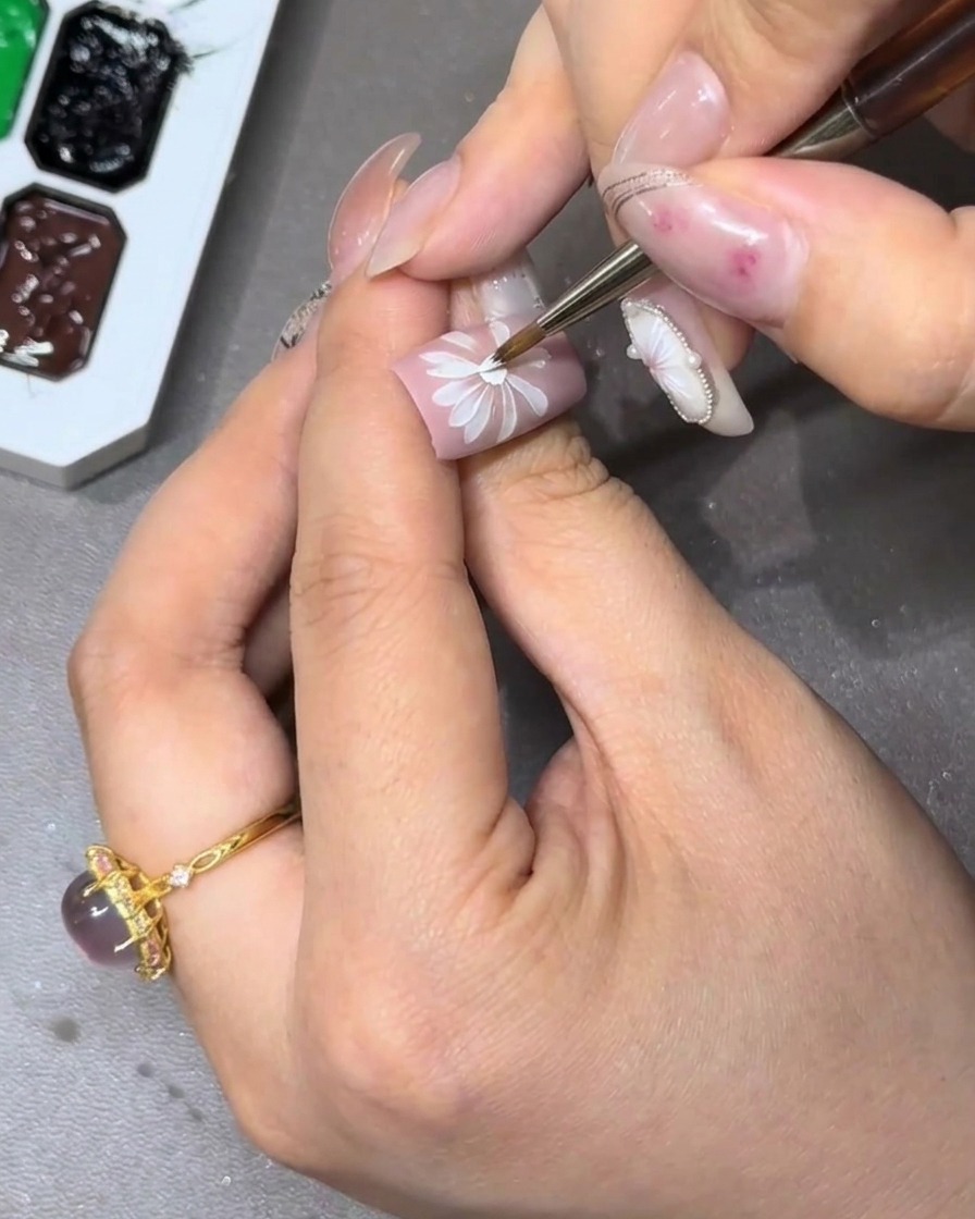 Nahaufnahme eines Nagels mit einem vollständigen, mehrschichtigen Blumen-Design.