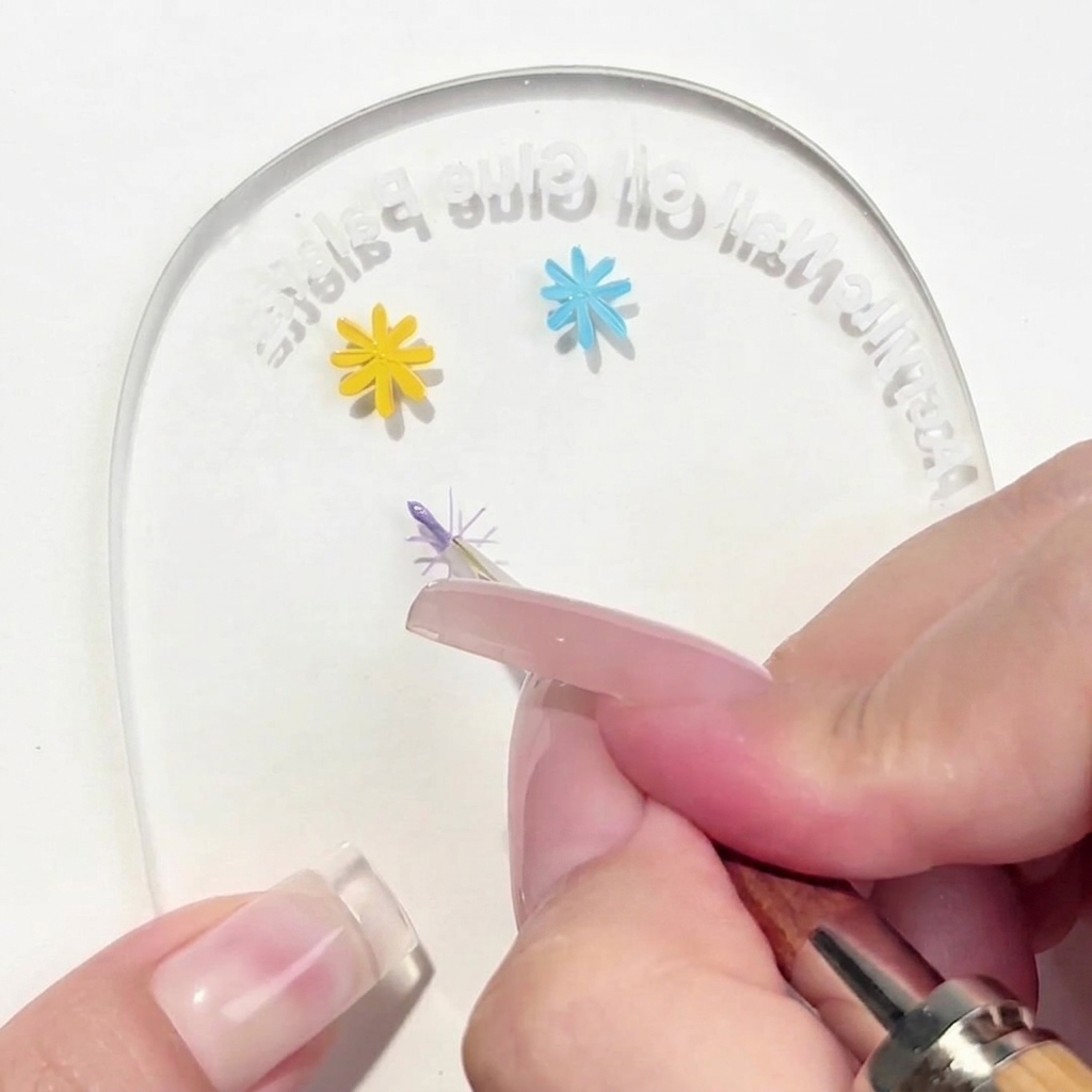 Ein Liner-Pinsel trägt ein einzelnes violettes Blütenblatt auf das zentrale Kreuz auf der Palette auf.