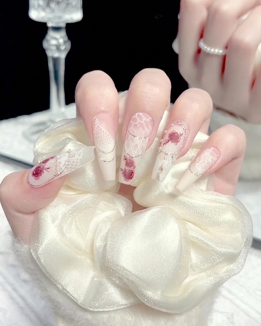 Ein Pinsel trägt eine kleine Menge weißes Gel auf die Nagelmitte auf.