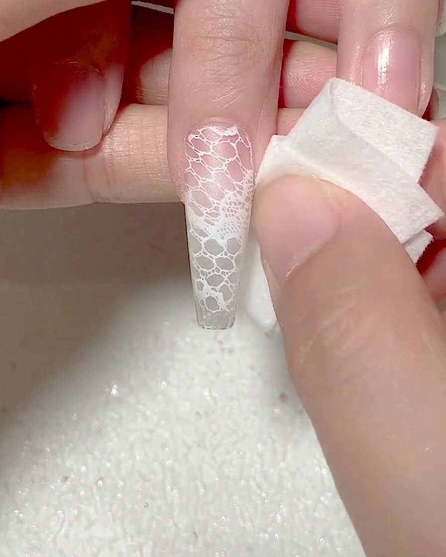 Ein Schwamm säubert überschüssiges Gel an den Nagelrändern.