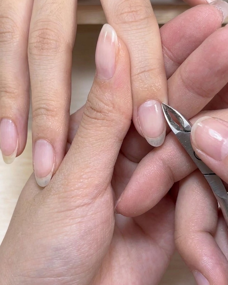 Nagelhautzangen trimmen vorsichtig überschüssige abgestorbene Haut um die Basis eines Fingernagels.
