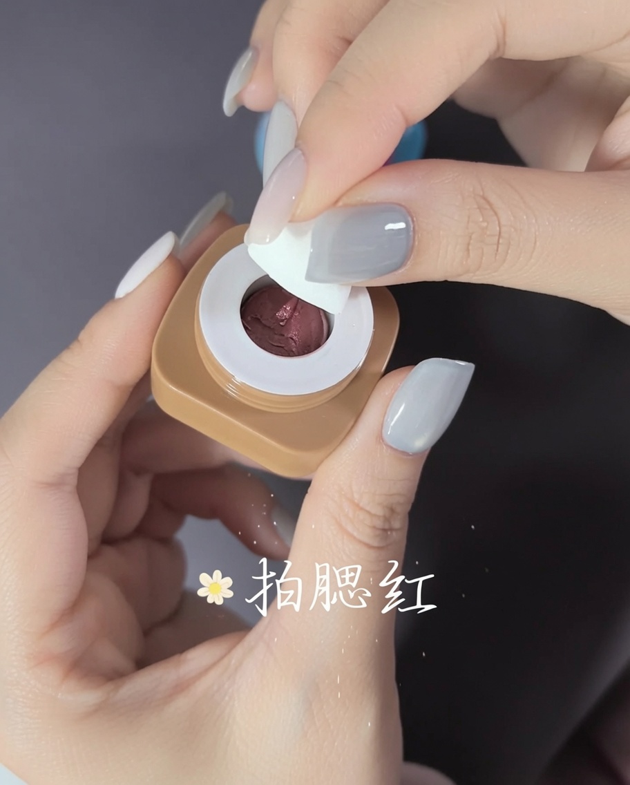 Nahaufnahme: Nagelkleber wird auf die Innenseite eines klaren Kunststoff-Nageltips aufgetragen.