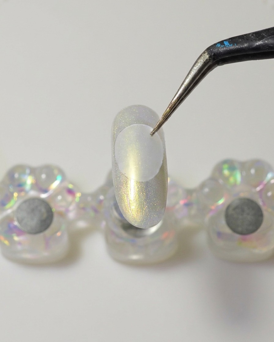 Ein Metallspatel trägt einen Klecks dickflüssiges, klares Solid-Builder-Gel auf die Unterseite einer Kunststoffscheibe auf.