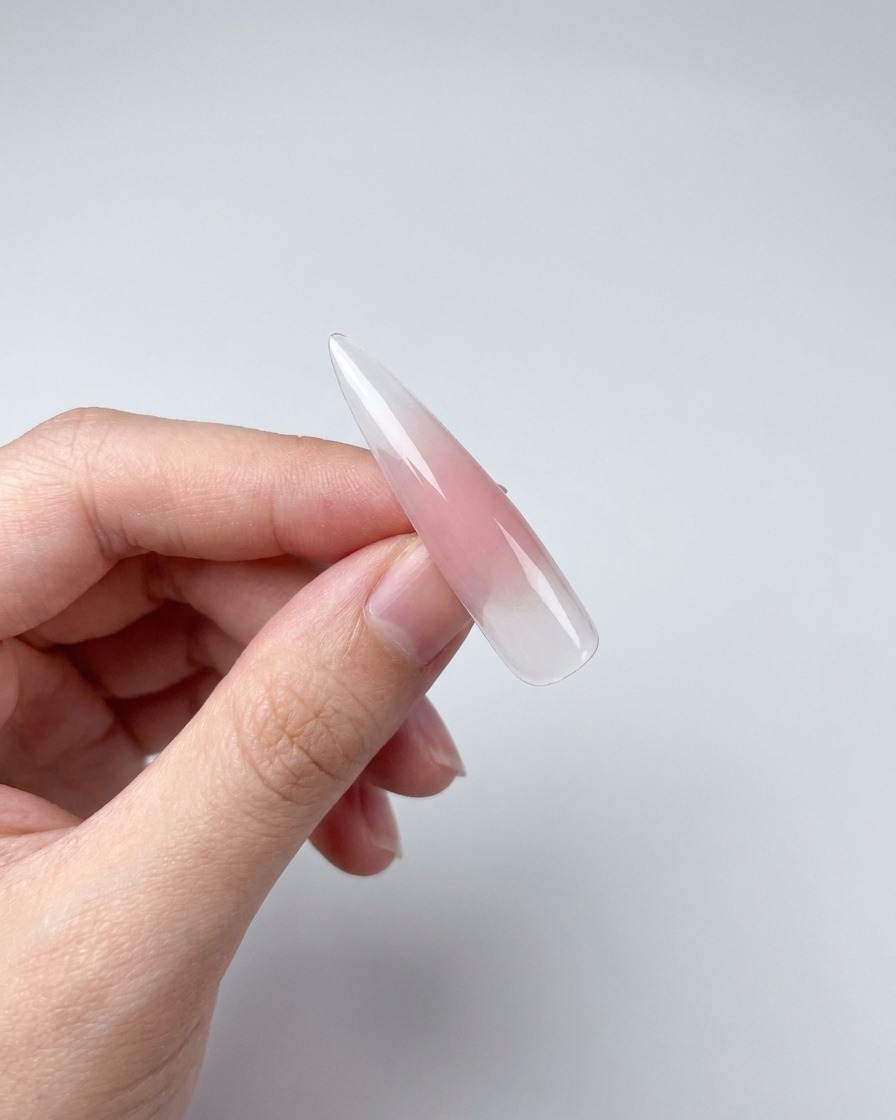 Nahaufnahme eines Nageltipps mit Magnetgel, das einen Schimmereffekt zeigt, der durch einen in der Nähe gehaltenen Magneten erzeugt wurde.