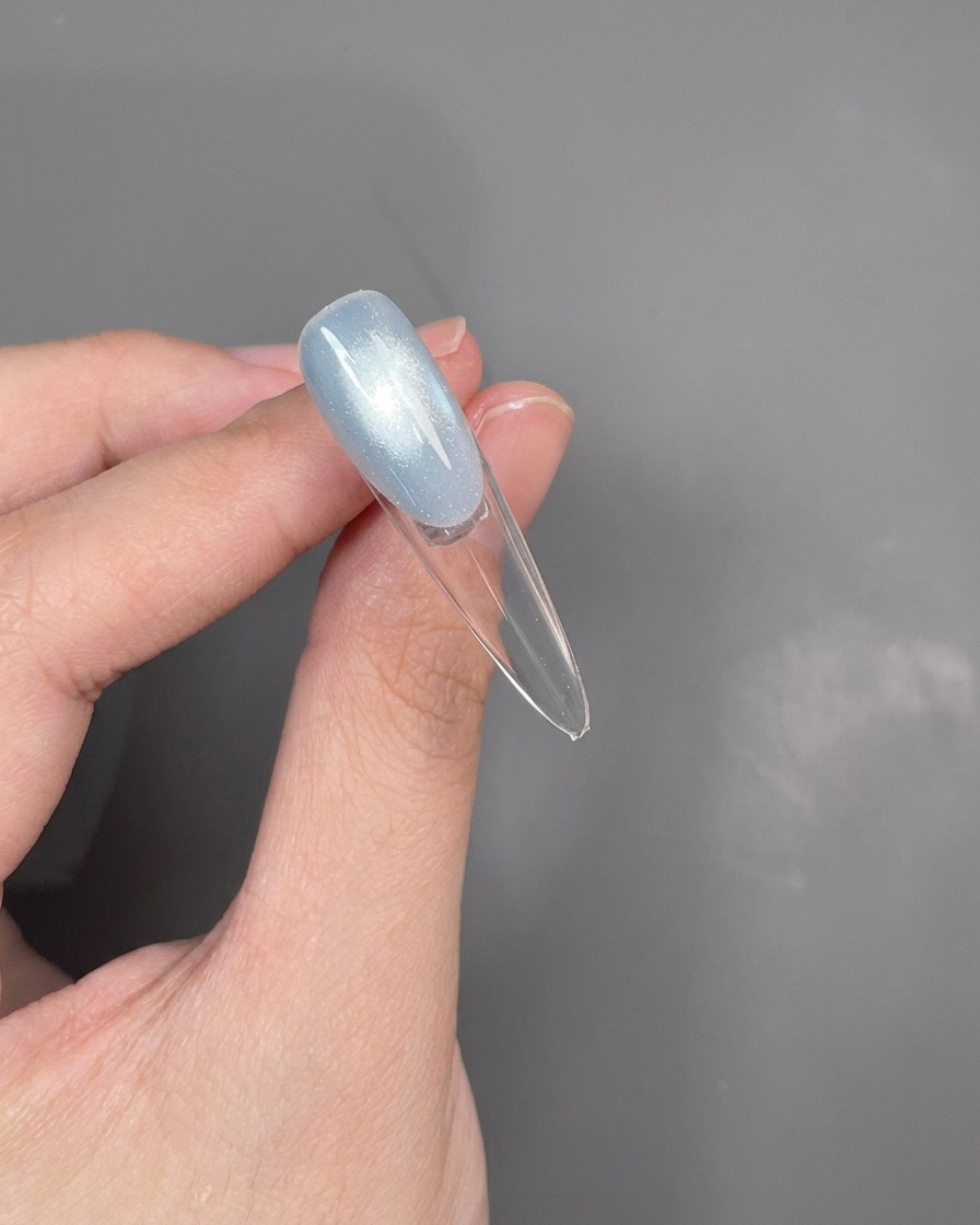 Nahaufnahme eines Dotting-Tools, das eine dünne, silberne Linie entlang der Smile-Line zieht.
