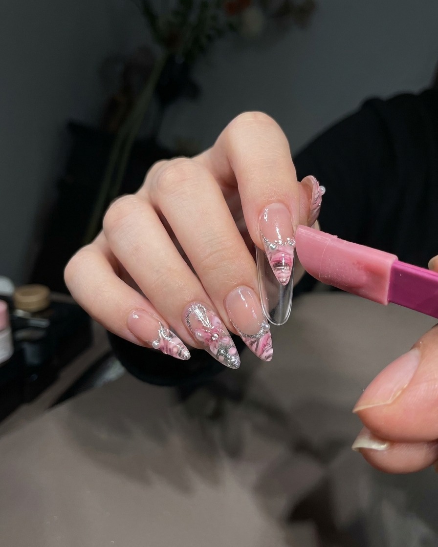 Eine Pinzette zieht vorsichtig einen French-Sticker vom ausgehärteten weißen Gel auf einem Nageltipp ab.