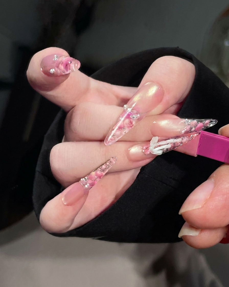 Nahaufnahme von Nägeln in einer UV/LED-Nagellampe mit eingeschaltetem Licht während des Aushärtens.