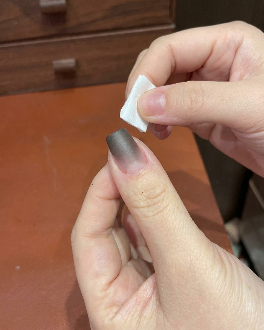Eine Hand platziert einen Finger unter einer kompakten UV/LED-Nagellampe.
