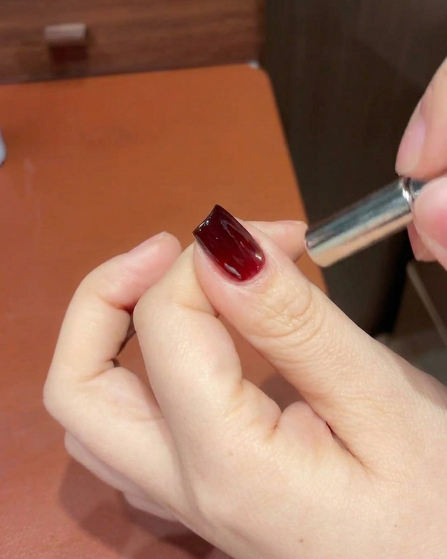 Ein Magnettool wird in der Nähe der Nagelspitze verwendet, um den Schimmer zu verfeinern.