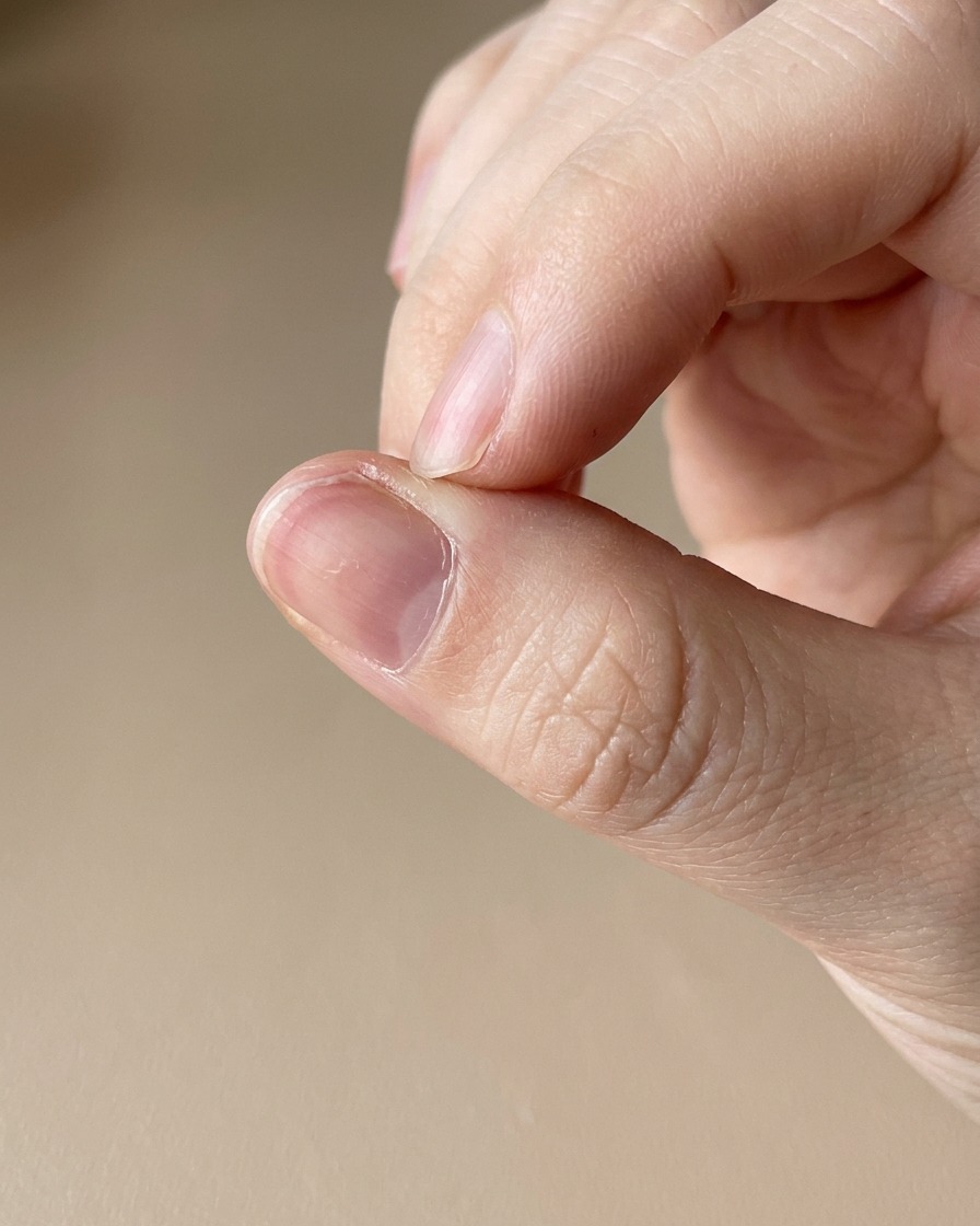 Ein Nagelhautöl-Stift pflegt die Haut um einen frisch manikürten Nagel.