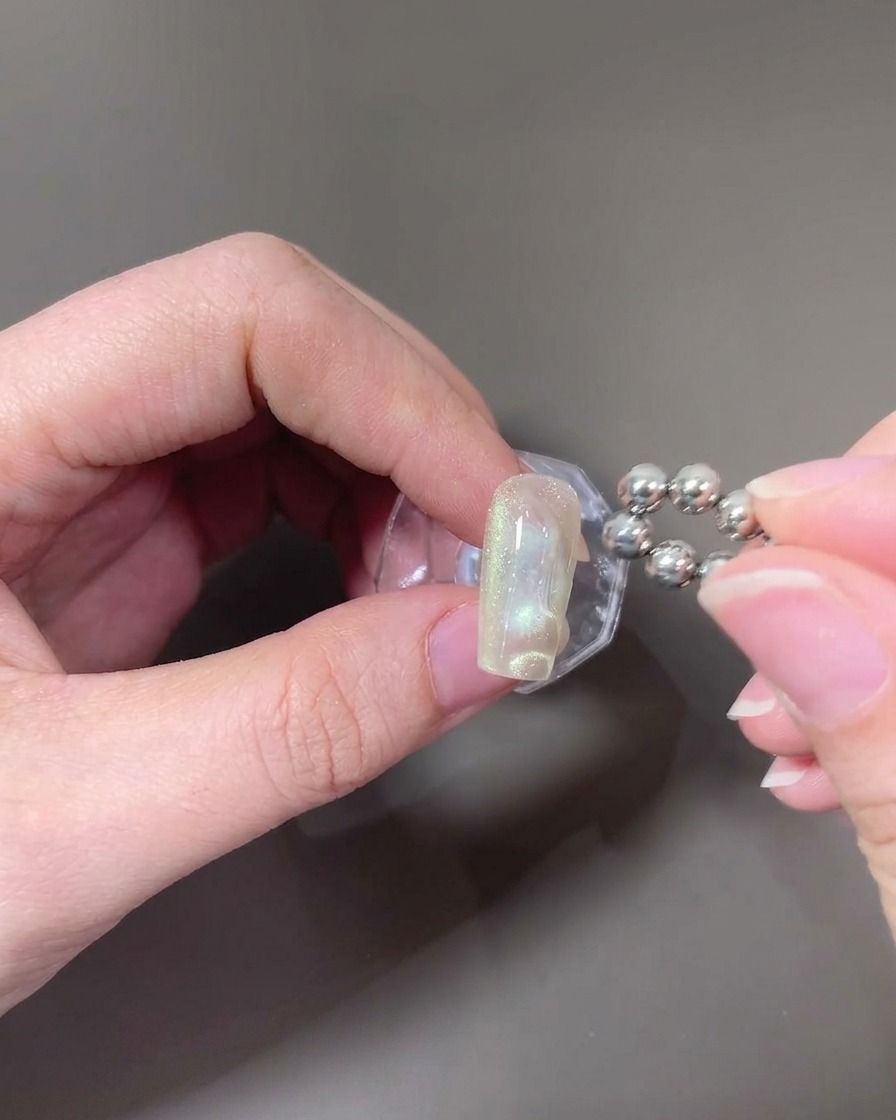 Ein kugelförmiger Magnet wird verwendet, um Wellenmuster im feuchten Cat-Eye-Gel zu erzeugen.