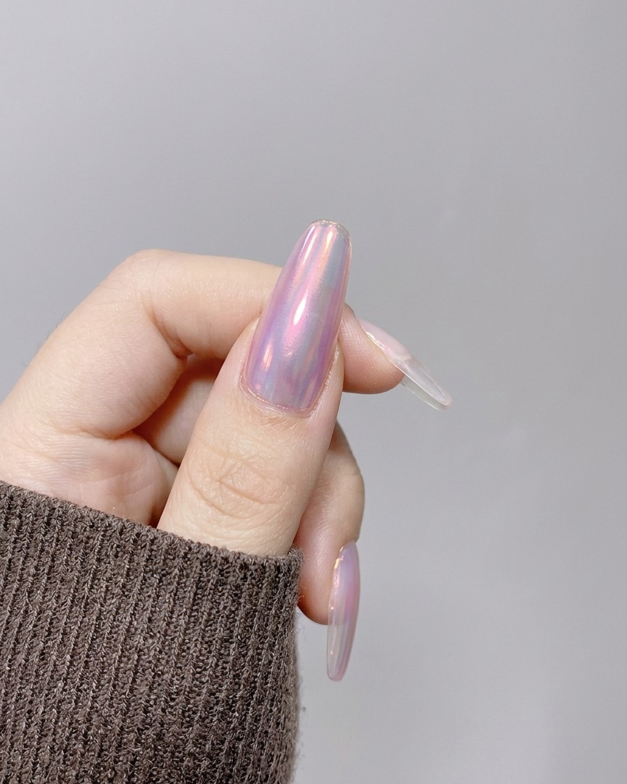 Eine Hand, die unter einer kompakten, pinken UV/LED-Handlampe positioniert ist, um die Nagelmodellage auszuhärten.