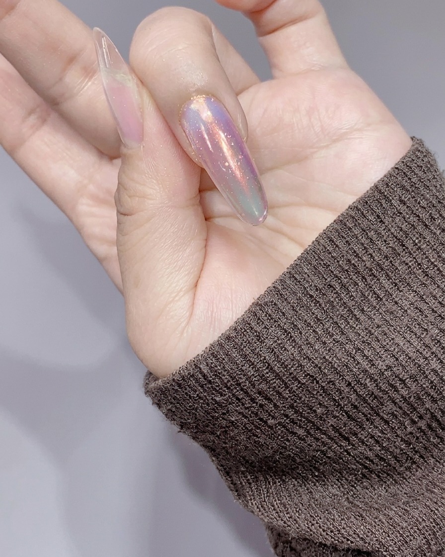 Die Nägel werden unter einer kleinen pinken UV/LED-Lampe nach dem Auftrag des Silber-Glitzer-Gels ausgehärtet.