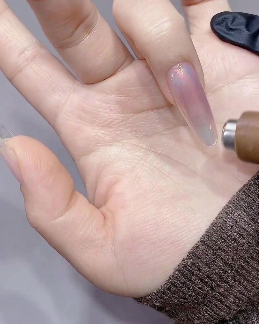 Der zylindrische Magnet wird entlang der rechten Seite des Nagels gezogen, wodurch eine scharfe Lichtlinie entsteht.