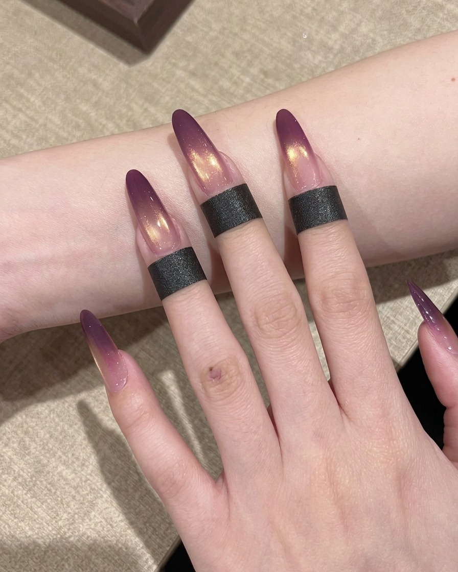 Eine Hand mit Ombré-Nägeln in einer professionellen UV-Nagellampe beim Aushärten.