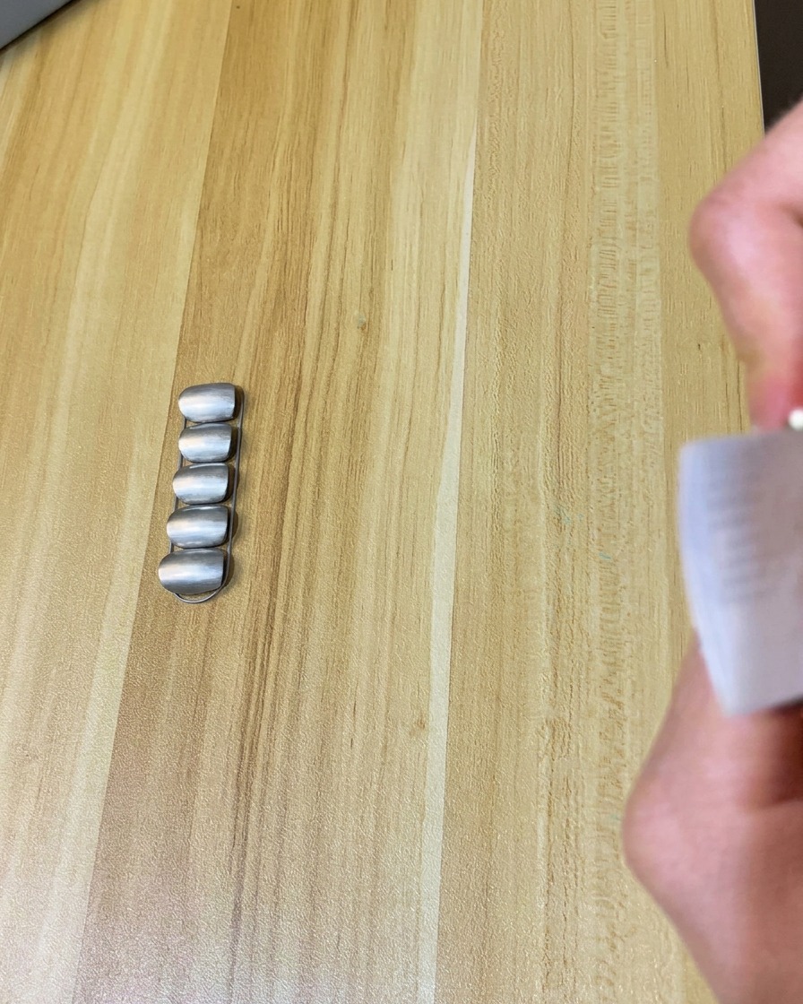 Ein fusselfreies Tuch wird verwendet, um die Oberfläche eines mattierten Nagels zu reinigen.