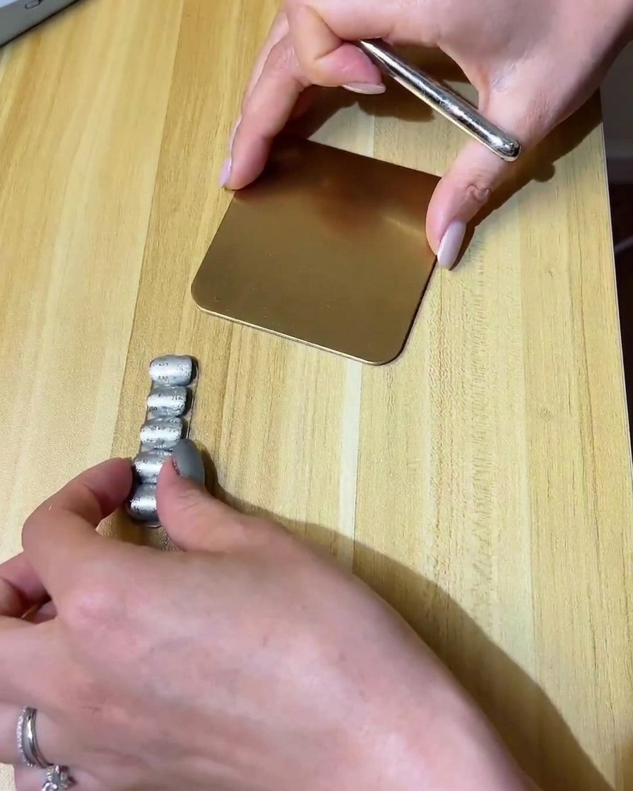 Ein feiner Liner-Pinsel malt ein kleines Wolkendesign mit klarem Gel auf einen matten Nagel.