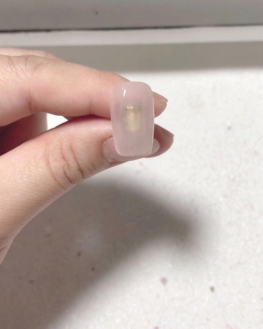 Ein manikürter Nagel wird zum Aushärten in eine professionelle Nagellampe gelegt.