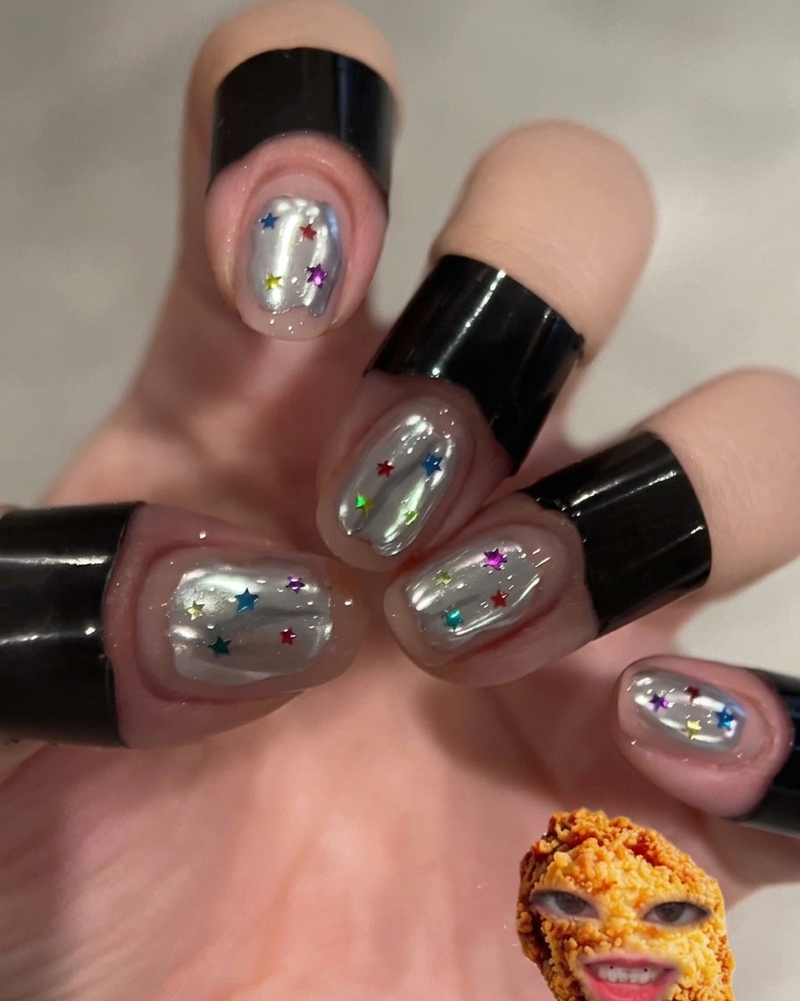Ein Finger reibt silbernes Chrome-Puder auf eine vorbereitete Nageloberfläche.