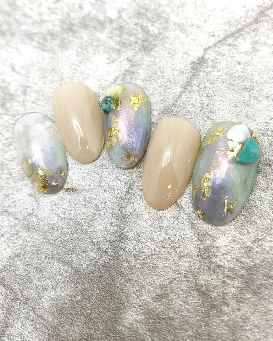 Eine Nahaufnahme einer Hand mit dem fertigen Marmor- und Blattgold-Nageldesign, das in einer professionellen UV/LED-Lampe aushärtet.