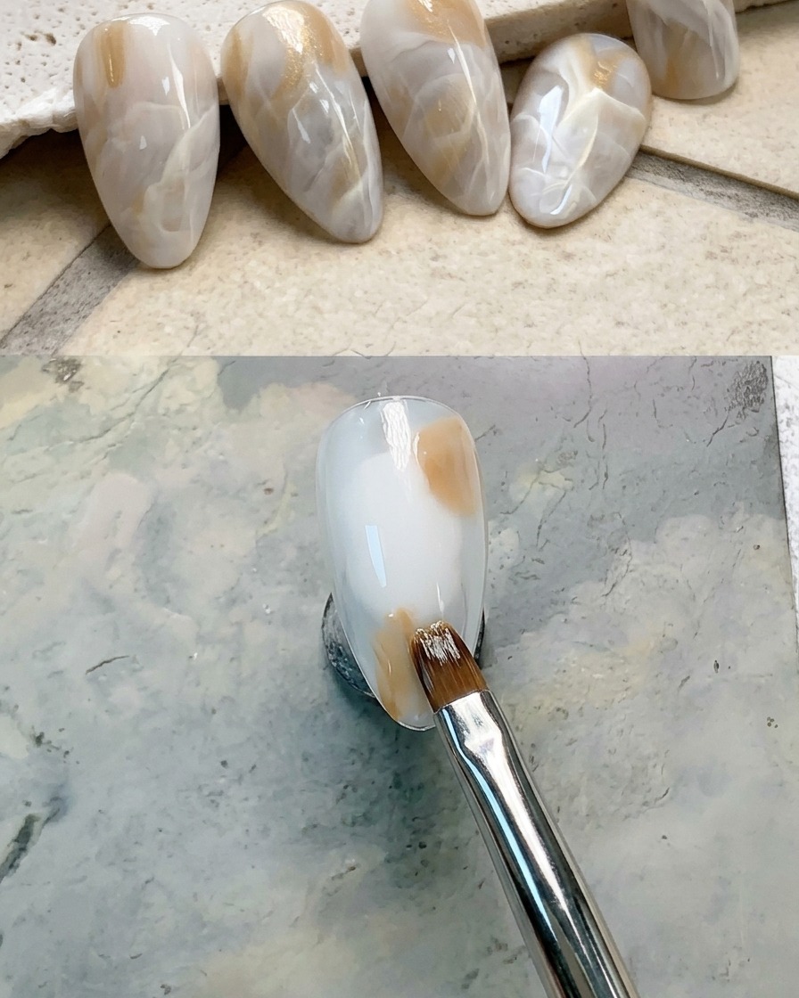 Nahaufnahme eines Nagels, auf dessen rechten oberen Bereich ein brauner Gel-Tupfer aufgetragen wird.