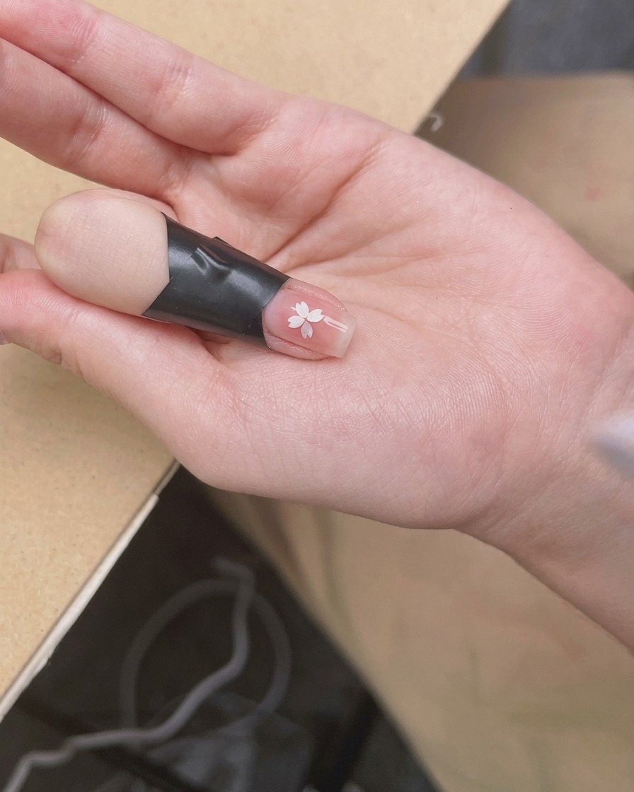 Ein Finger unter der UV/LED-Lampe, während das Licht auf den Nagel fällt.