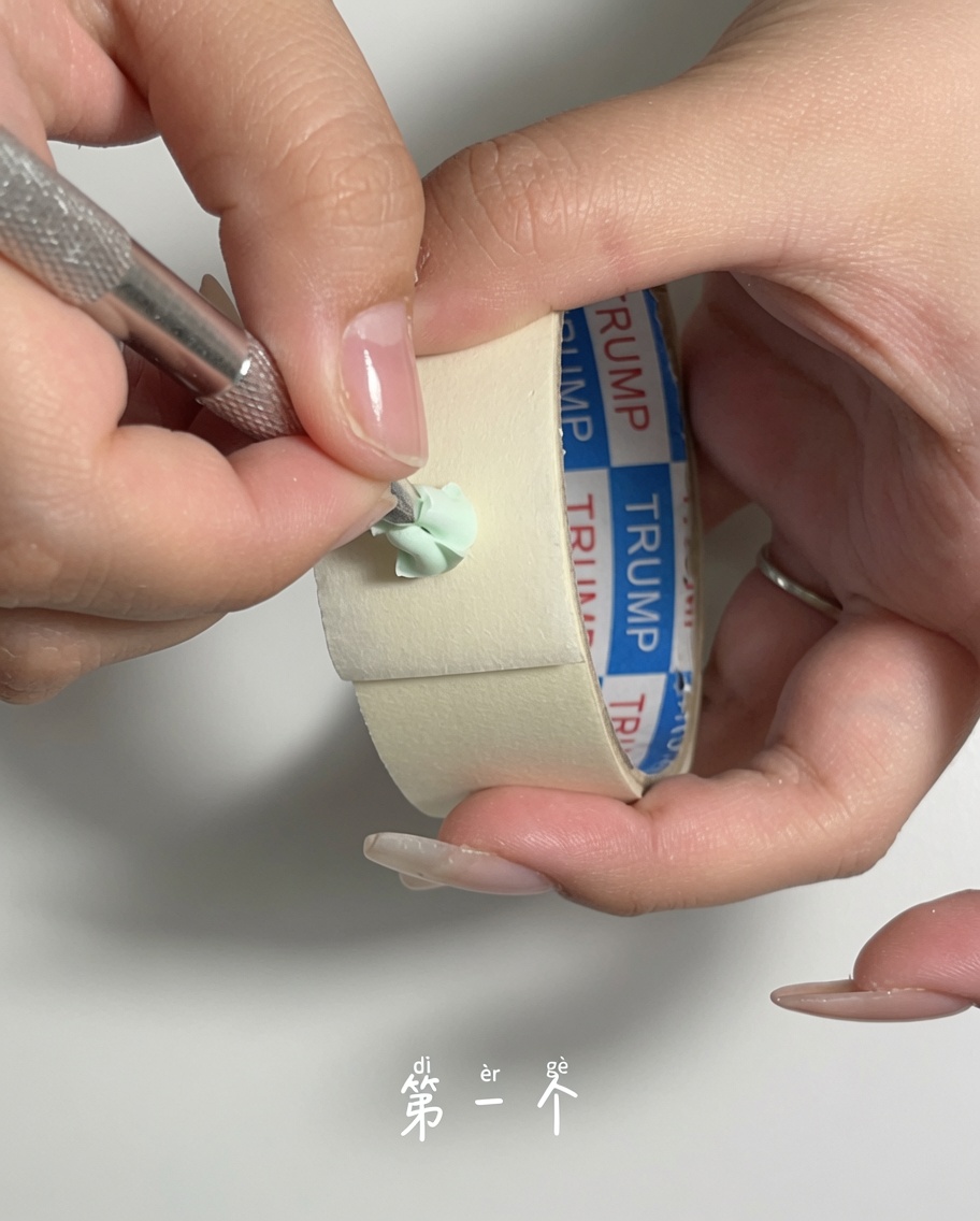 Ein Nagelhautschieber aus Metall entfernt vorsichtig Staub von einem grünen Make-up-Schwamm.