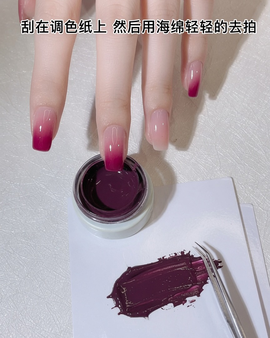 Ein weißer Make-up-Schwamm wird in eine dünne Schicht purpur-rosa Gel auf einer Palette gedrückt.