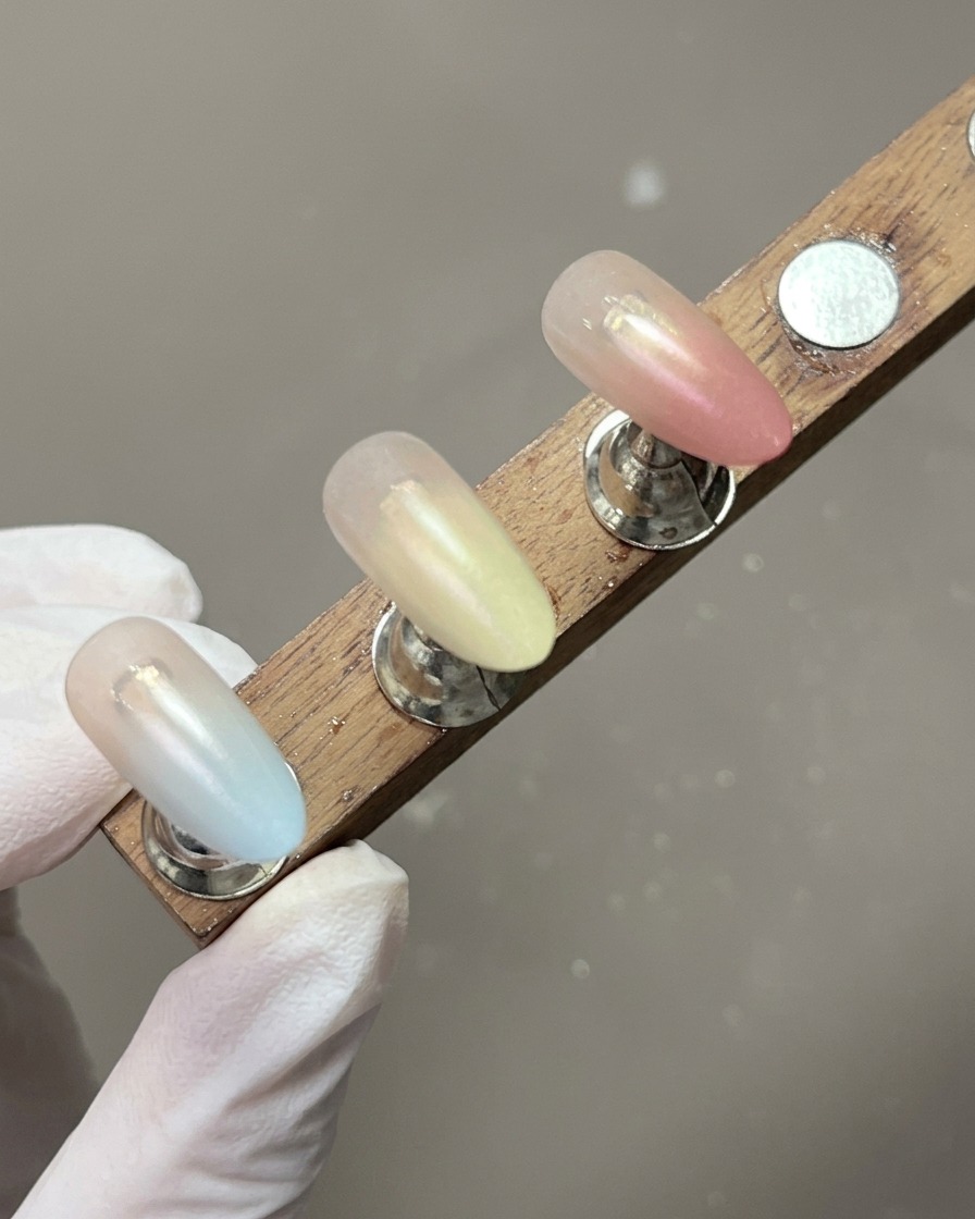 Ein Ständer mit Nagelspitzen, die fertige, sanfte Pastellverläufe zeigen.