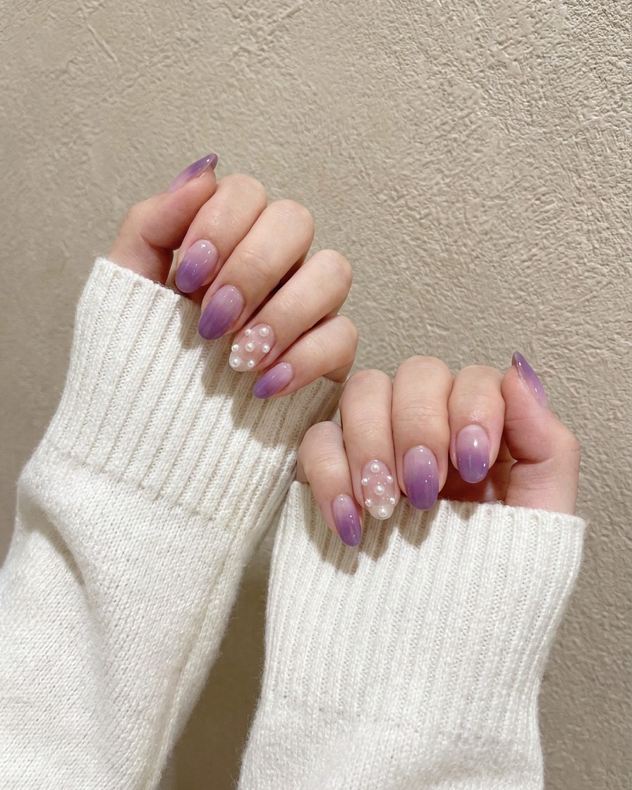 Ein Detail-Pinsel tupft dunkles Lila auf die Spitze eines hellen Nagels.