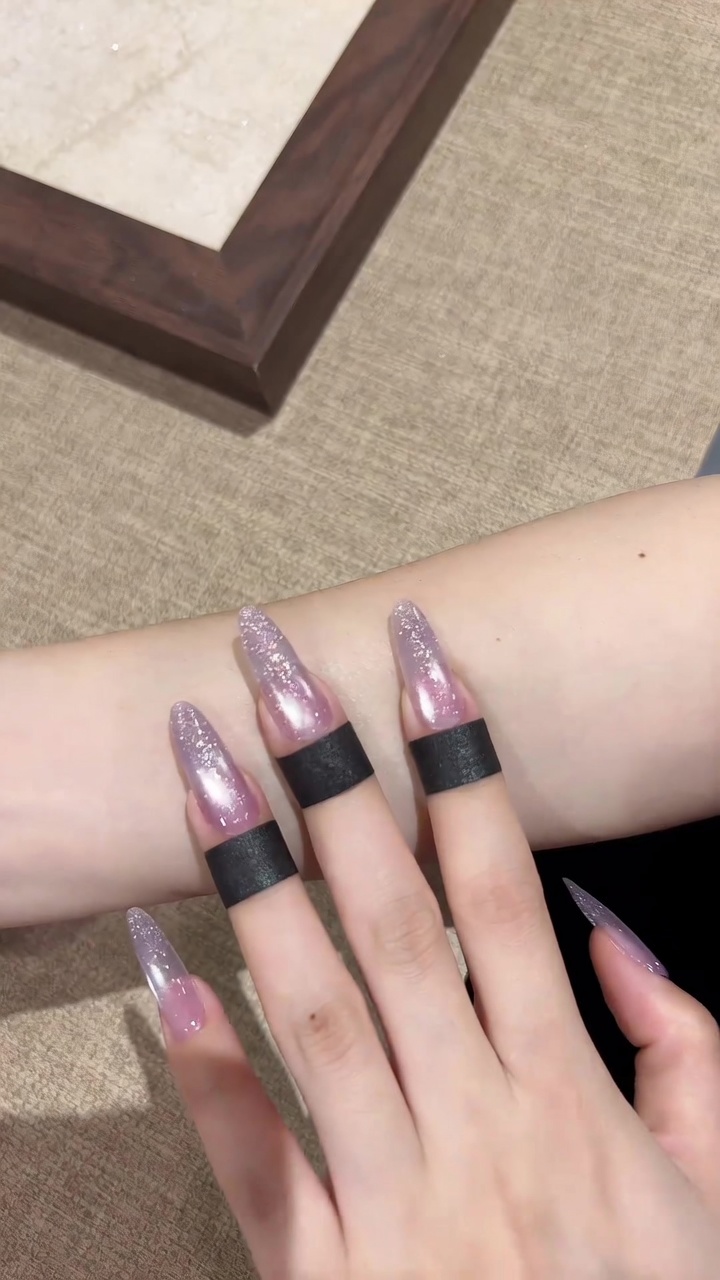 Lange, mandelförmige Nägel mit einem raffinierten Übergang von einer zarten, transparenten violetten Cat-Eye-Basis zu einer lebendigen, schimmernden Glitzer-Spitze.