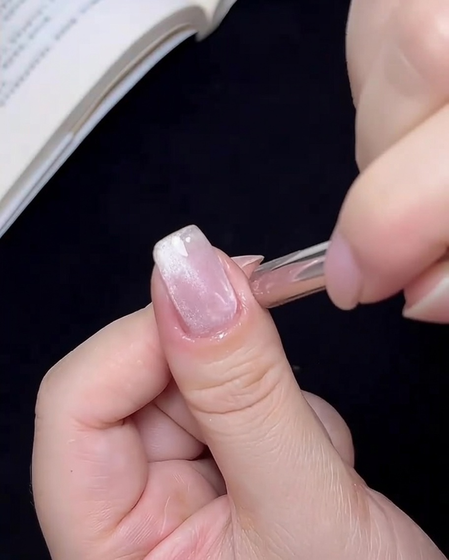 Der Magnet wird in einer kreisenden Bewegung um den Nagel geführt, um die Cat-Eye-Partikel in einem zentralen Punkt zu fokussieren.