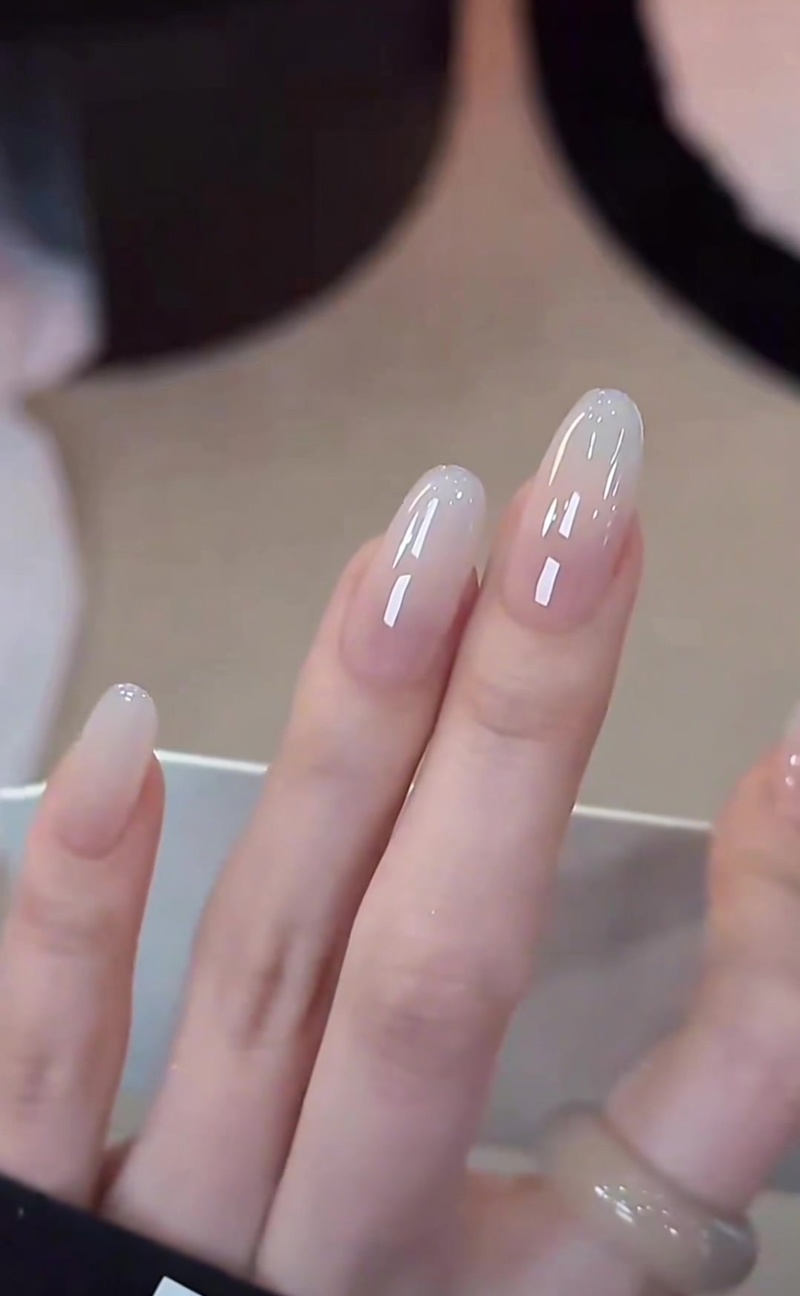 Klassische Milky White Gradient Nails mit einem nahtlosen Übergang von einer transparenten Basis zu einer deckenden, glänzenden weißen Spitze.