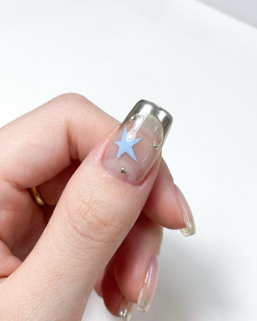 Metallischer Nagelhautschieber beim Zurückschieben der Nagelhaut an einem Naturnagel.