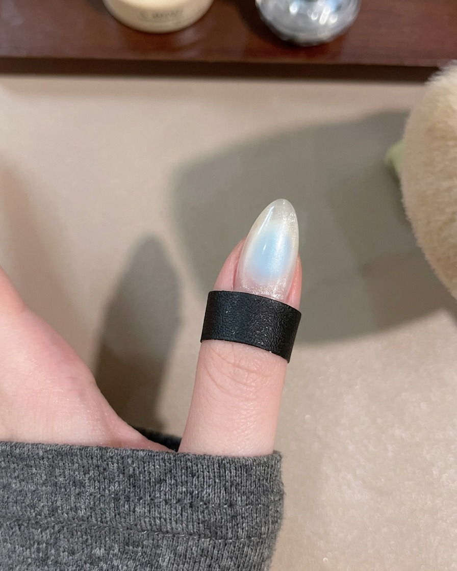 Eine Hand unter der tragbaren LED-Lampe zum Aushärten des mittleren Gel-Details.